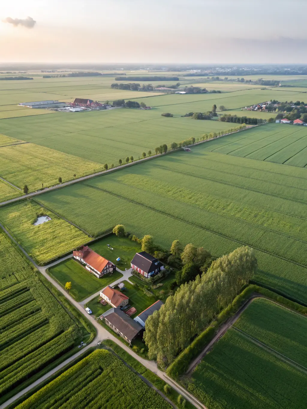 Aerial view of a vast, green field in the Netherlands, perfectly situated for a large-scale data center, showcasing the potential for development and strategic location.